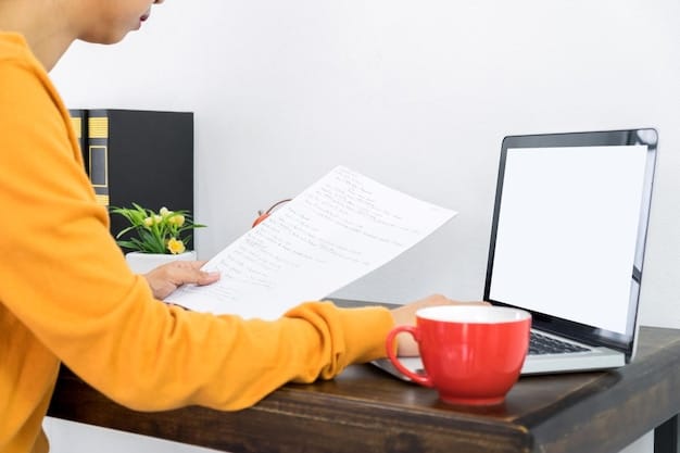 A person sitting at a desk, working on a laptop with a tax form displayed on the screen, and a cup of coffee nearby.