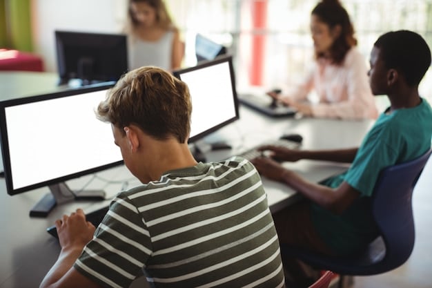 A student intently focused on a computer screen during a coding workshop, with lines of code visible and a collaborative coding environment in the background.