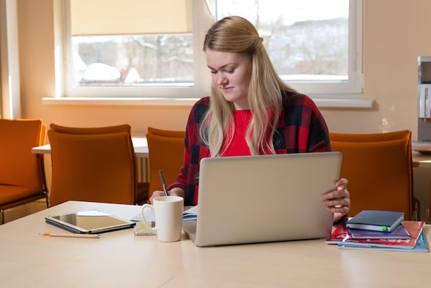 A student sitting at a desk, carefully reviewing their scholarship application and profile on a laptop screen.