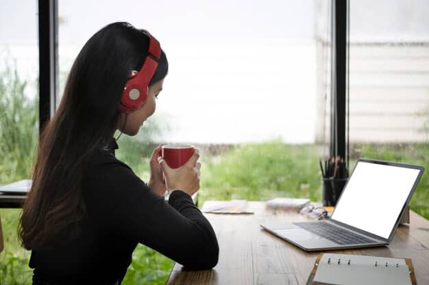 A student working diligently at a desk, wearing noise-canceling headphones and using a website blocker on their laptop. The background is blurred to emphasize the student's focus.