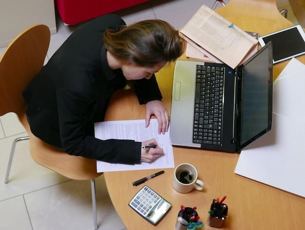 A person sitting at a desk, reviewing documents related to student loan repayment, with a calculator and laptop nearby, symbolizing financial planning and awareness.