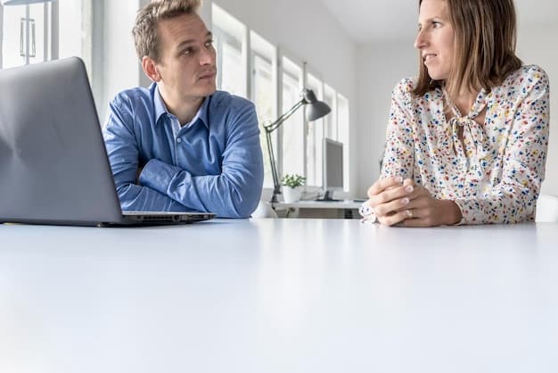 Two colleagues engaged in a productive discussion in a bright, minimalist office, focusing on effective negotiation demonstrated through open communication and collaborative problem-solving.