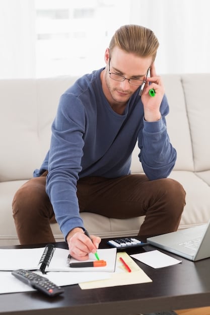 Image of a person sitting at a desk reviewing financial documents and using a calculator, representing careful financial planning and preparation for tax changes.