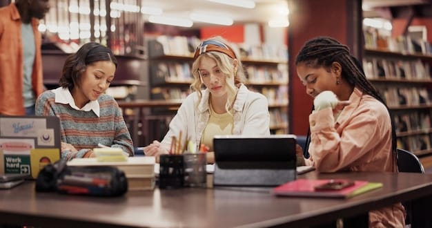A student practicing interview answers with a friend in a library. They are both smiling and engaged, with notes and a laptop on the table, illustrating focused preparation.